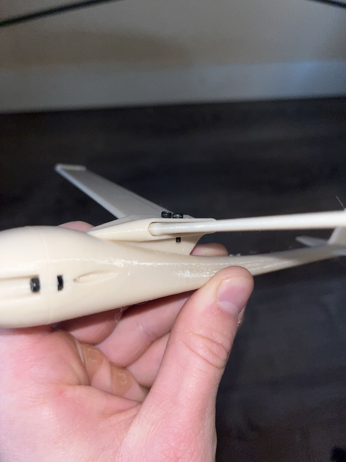 Close view of the printed glider wing attachment and small black fasteners